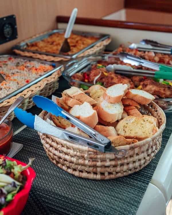 The buffet lunch on board: bread basket, salads and hot trays