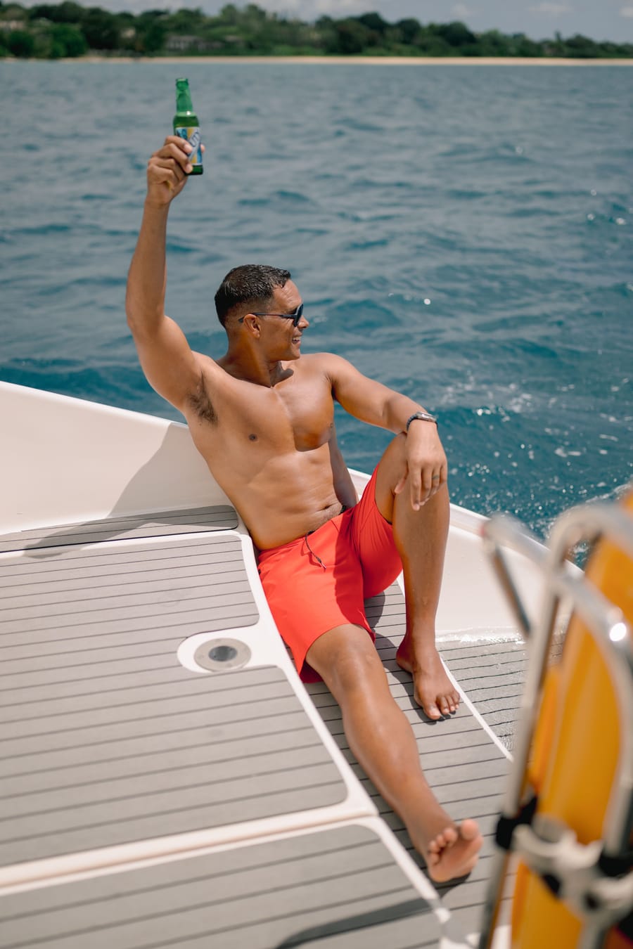 A guest raising a bottle in celebration on deck