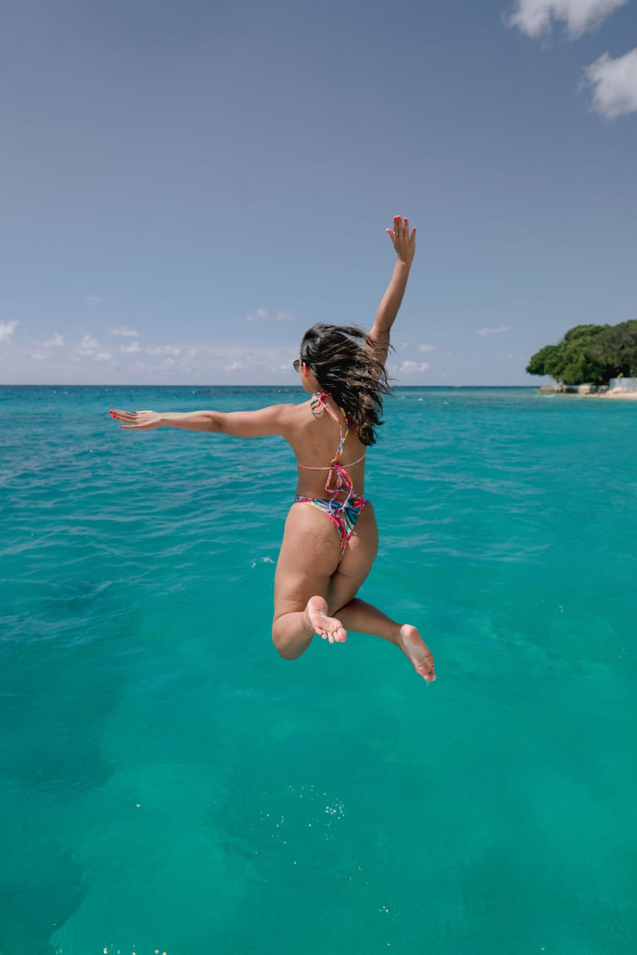 A guest jumping off the boat into turquoise water
